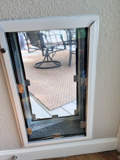 Double flap dog door installed into wall.