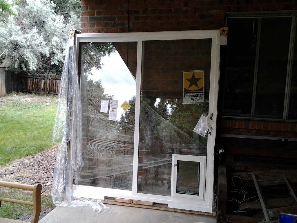 This is sold to a DIY customer. A brand-new Pella slider with a Hale pet door installed.